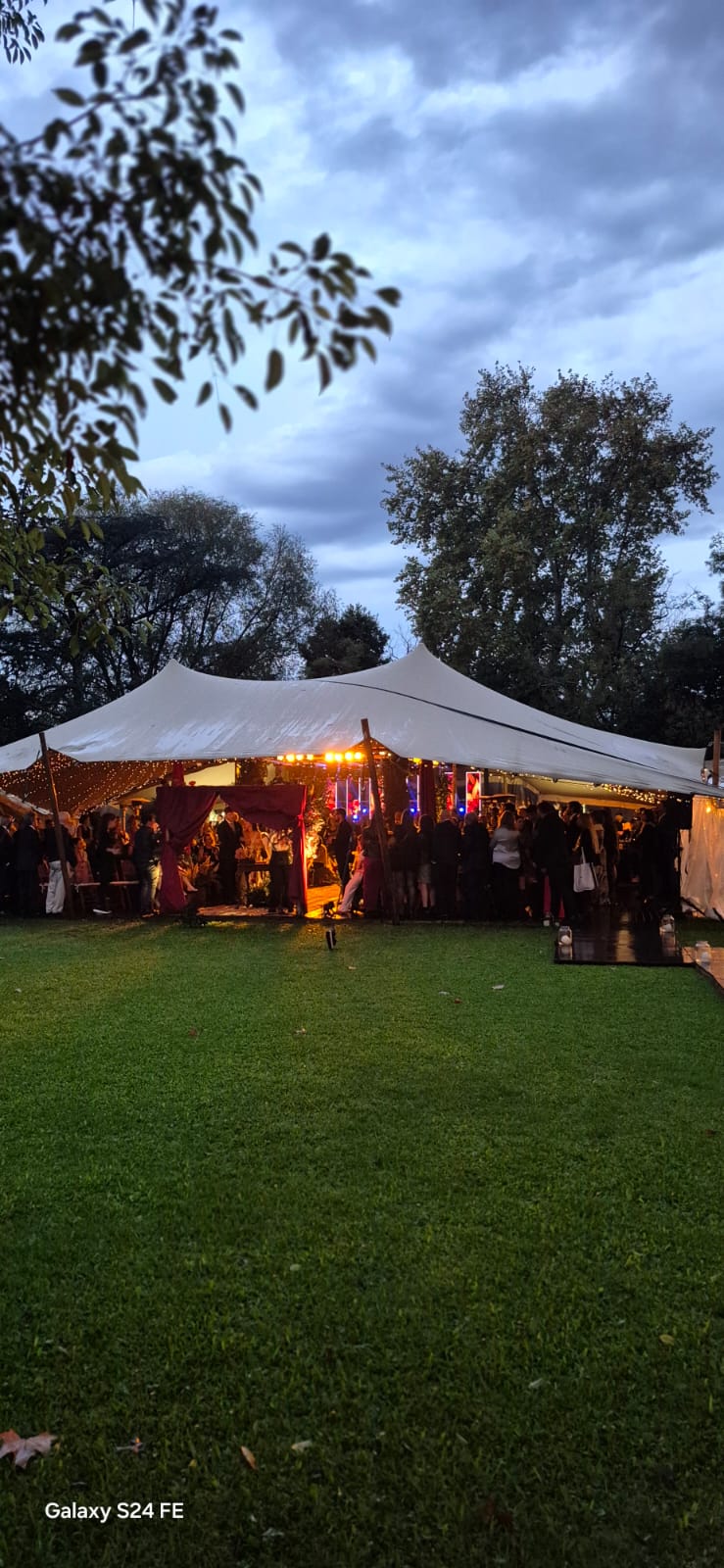Carpa iluminada en un evento al aire libre al atardecer